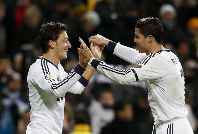 Real Madrid's Mesut Ozil celebrates his goal against Atletico Madrid with teammate Cristiano Ronaldo during their Spanish first division soccer match at Santiago Bernabeu stadium in Madrid